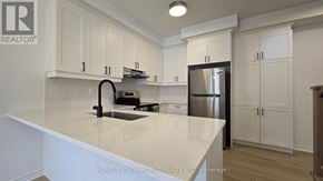 Markham townhouse for rent - A kitchen with white cabinets and a black faucet.