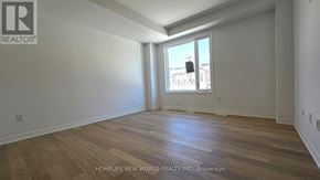Markham townhouse for rent - A room with wooden flooring and a window overlooking a cityscape.
