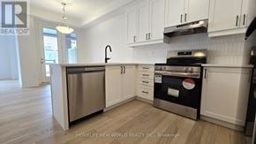 Markham townhouse for rent - A kitchen with white cabinets and a stainless steel dishwasher.