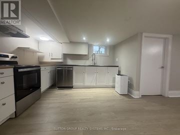 Toronto (Mount Dennis) apartment for rent - A kitchen with white cabinets and appliances in a house.