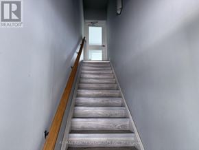 Waterloo townhouse for rent - A long flight of wooden stairs leads to a door.