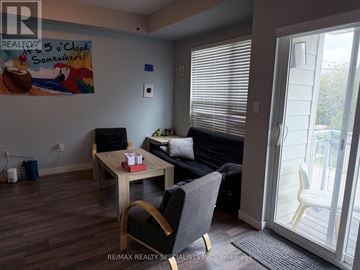Waterloo townhouse for rent - A living room with a couch, chair, and a painting on the wall.