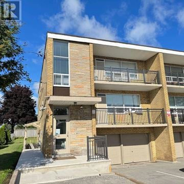 Toronto (Bathurst Manor) triplex for rent - A multi-story apartment building with balconies and garage doors.