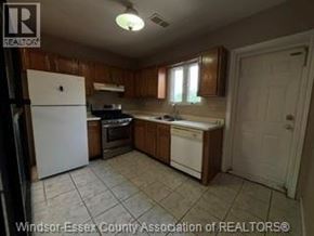 Windsor apartment for rent - A kitchen with white appliances and wooden cabinets.