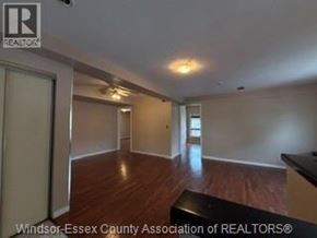 Windsor apartment for rent - A spacious room with wooden floors and white walls.