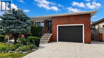 Hamilton apartment for rent - A house with a red brick exterior and a black garage door.
