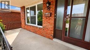 Hamilton apartment for rent - A red brick house with a glass door and a window.