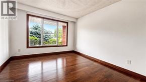 Hamilton apartment for rent - A room with a window showing a view of trees and a brick building.