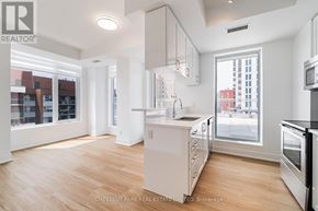 Toronto (Mount Pleasant West) condo for rent - A well-lit, spacious kitchen with wooden floors and white cabinetry.
