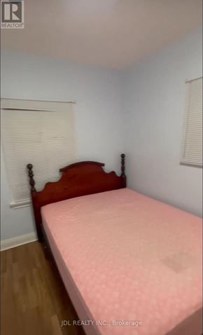 Toronto (Pleasant View) apartment for rent - A bed with a pink cover sits in a room with white walls.