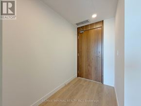 Toronto (Bayview Village) condo for rent - A room with a wooden door and a white wall.