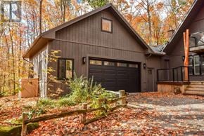 Oro-Medonte apartment for rent - A house with a brown garage door is surrounded by a forest.