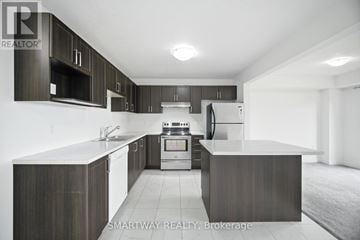 Grey Highlands townhouse for rent - A modern kitchen with dark wood cabinets and stainless steel appliances.