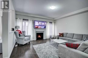 Cambridge apartment for rent - A living room with a grey sofa, a grey armchair, a fireplace, and a television.