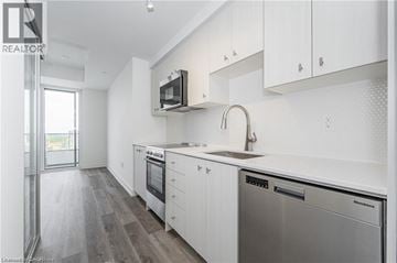 Kitchener condo for rent - A modern kitchen with white cabinets and stainless steel appliances.