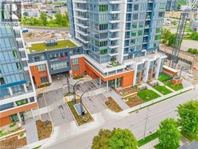 Kitchener condo for rent - A modern building with a green roof and a courtyard in the foreground.