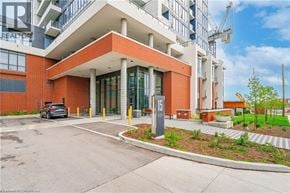Kitchener condo for rent - A modern building with a red brick facade and a glass entrance.