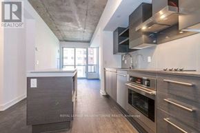 Toronto (Niagara) condo for rent - A modern kitchen with stainless steel appliances and a wooden floor.