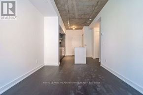Toronto (Niagara) condo for rent - A white room with a wooden floor and a white column.