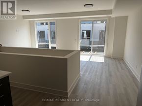 St. Catharines (Oakdale) townhouse for rent - A room with a large window and a view of a building outside.