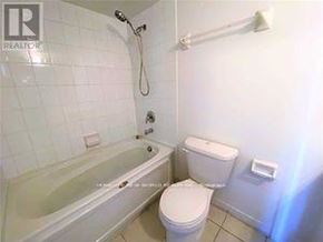 Toronto (Bendale) condo for rent - A white toilet sits next to a bathtub in a bathroom.