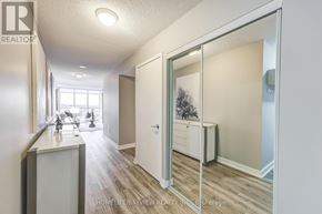 Toronto (Bayview Village) condo for rent - A hallway with a white door and a mirror on the wall.