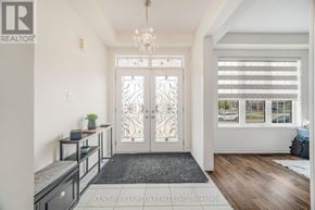 Thorold (Hurricane/Merrittville) apartment for rent - A foyer with a chandelier, a bench, and a door with a glass panel.