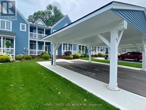 Central Elgin (Port Stanley) townhouse for rent - A blue building with a white roof and a carport.