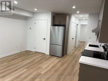 Toronto (Weston-Pellam Park) multi-family for rent - A kitchen with a refrigerator, sink, and cabinets.