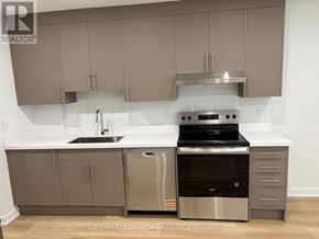 Toronto (Weston-Pellam Park) multi-family for rent - A modern kitchen with stainless steel appliances and beige cabinets.