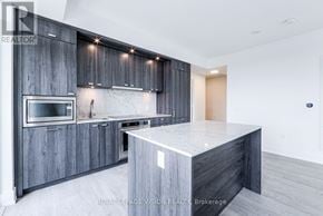 Toronto (Dovercourt-Wallace Emerson-Junction) condo for rent - A modern kitchen with dark wood cabinets and a marble countertop.