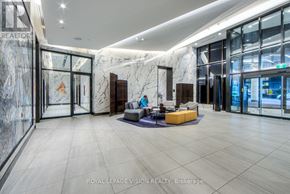 Toronto (Waterfront Communities) condo for rent - A spacious lobby with a marble wall and a large glass door.