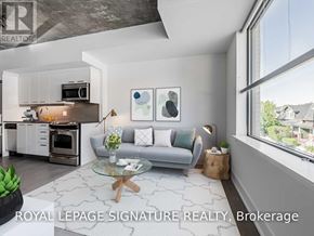 Toronto (South Riverdale) condo for rent - A modern living room with a grey sofa, a glass coffee table, and a kitchen area in the background.
