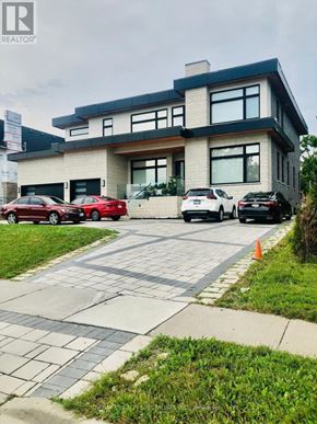 Pickering (Liverpool) apartment for rent - A modern house with a black car and a red car parked in front.