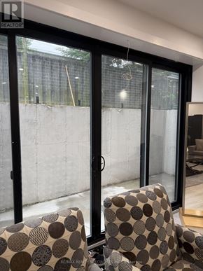 Pickering (Liverpool) apartment for rent - A chair with a patterned cushion sits in front of a glass door.
