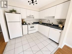 Whitby (Pringle Creek) townhouse for rent - A white kitchen with a refrigerator, oven, and sink.