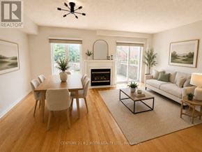 Whitby (Pringle Creek) townhouse for rent - A living room with a fireplace and a dining table.