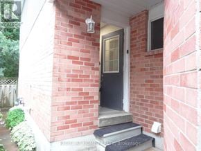 Clarington (Courtice) apartment for rent - A red brick house with a black door and a small porch.