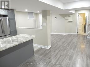 Clarington (Courtice) apartment for rent - A kitchen with a marble countertop and a refrigerator.