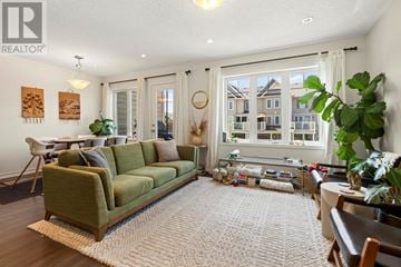 Oakville (Go Glenorchy) townhouse for rent - A living room with a green couch and a large window.