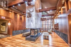 Mississauga (City Centre) condo for rent - A large room with wood floors and a fireplace.