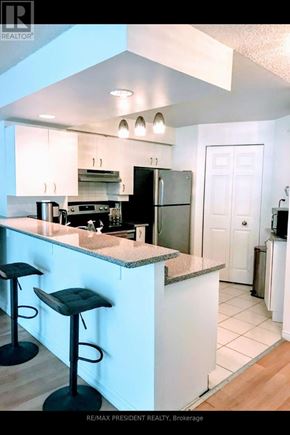 Toronto (Niagara) condo for rent - A kitchen with a bar area and a refrigerator.