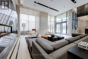 Toronto (Annex) condo for rent - A modern living room with a grey sofa and a glass wall.
