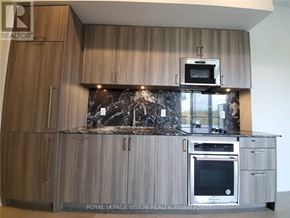 Toronto (Annex) condo for rent - A modern kitchen with wooden cabinets and a marble backsplash.