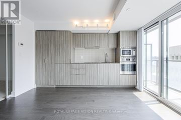 Toronto (Bay Street Corridor) condo for rent - A modern kitchen with a large island and a microwave built into the cabinetry.