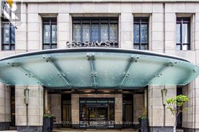 Toronto (Bay Street Corridor) condo for rent - The entrance to a building with a large glass door and a green canopy.