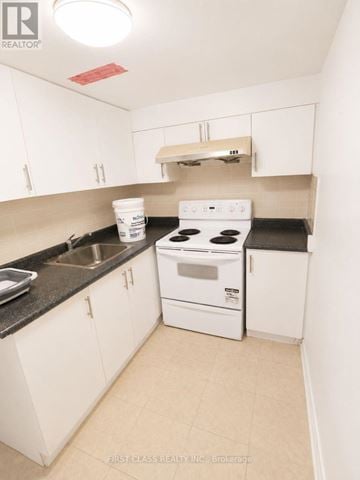 Toronto (Agincourt North) apartment for rent - A small white kitchen with a stove and sink.