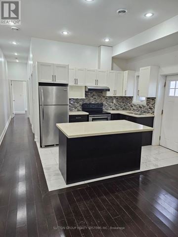 Toronto (Danforth) apartment for rent - A kitchen with white cabinets and a black island.