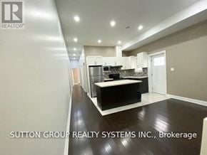 Toronto (Danforth) apartment for rent - A modern kitchen with a black countertop and white cabinets.