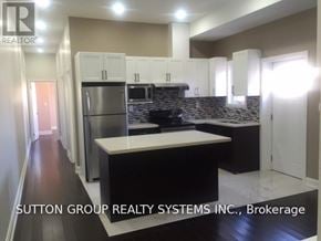 Toronto (Danforth) apartment for rent - A kitchen with a refrigerator, microwave, and cabinets.